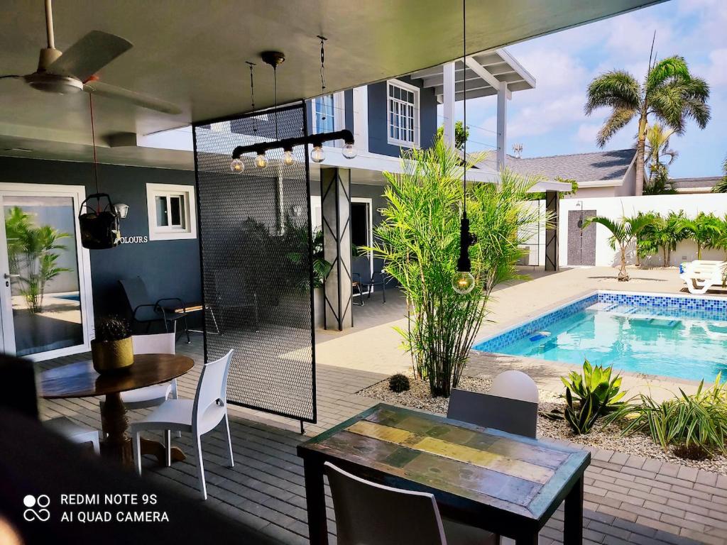 棕榈滩Studios 11and11Aruba的一个带桌椅的庭院和一个游泳池