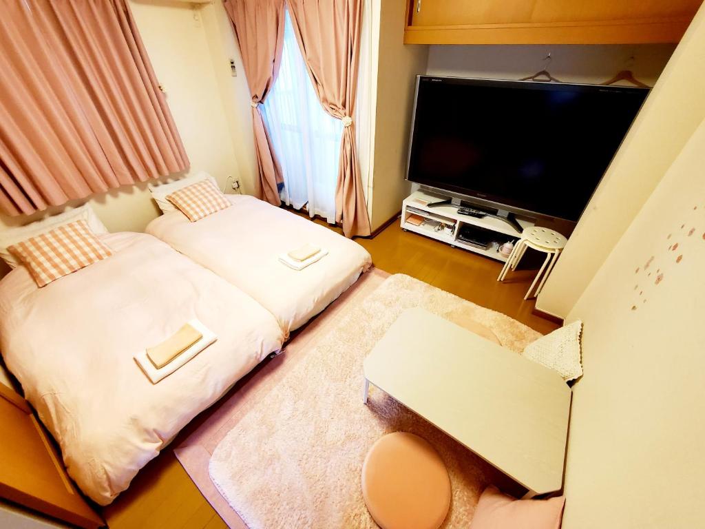 神户Takaraboshi room 301 Sannomiya 10 min的小房间设有两张床和一台平面电视