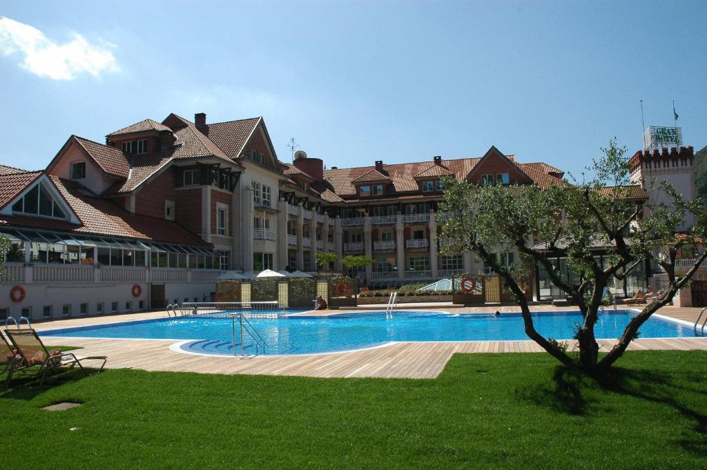 蓬特维耶斯戈普恩特维斯戈水疗大酒店的一座大建筑,在院子里设有大型游泳池