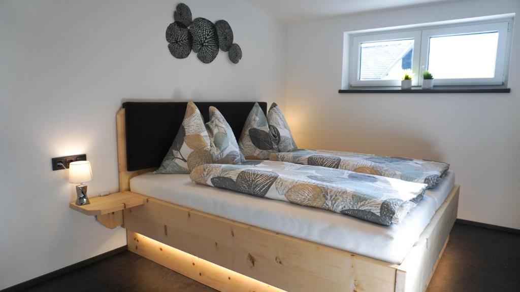 大基希海姆Sky Appartement的一间卧室配有一张木框床和窗户。