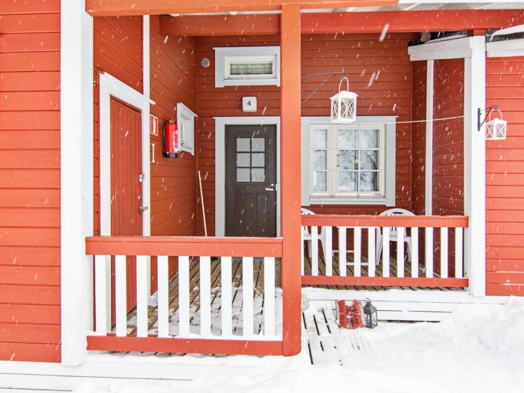 KotilaHoliday Home Lomarivi c4 by Interhome的雪中带前门的红色房子