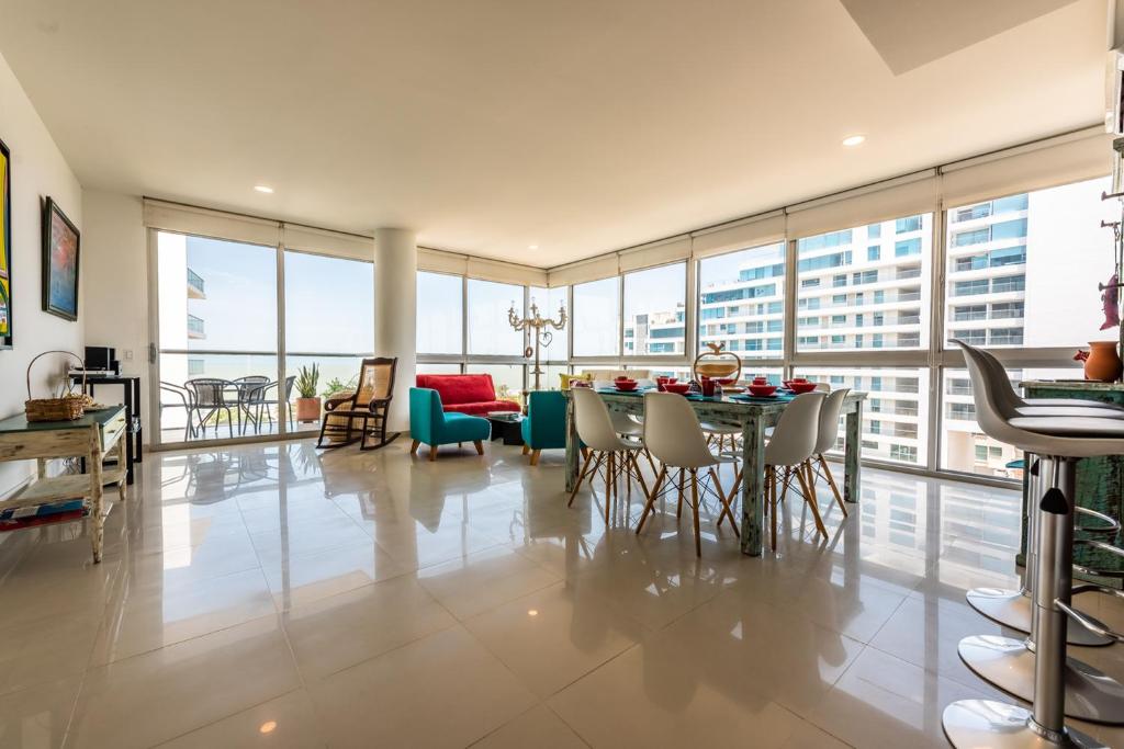 卡塔赫纳Edificio Morros Vitri Lujo con Panorama的用餐室以及带桌椅的起居室。