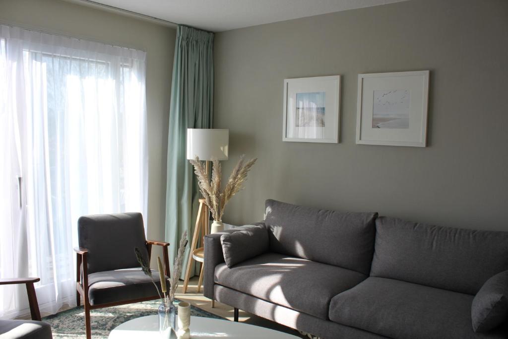 霍勒姆Appartement, Kaap 123 - Ameland的客厅配有沙发和椅子