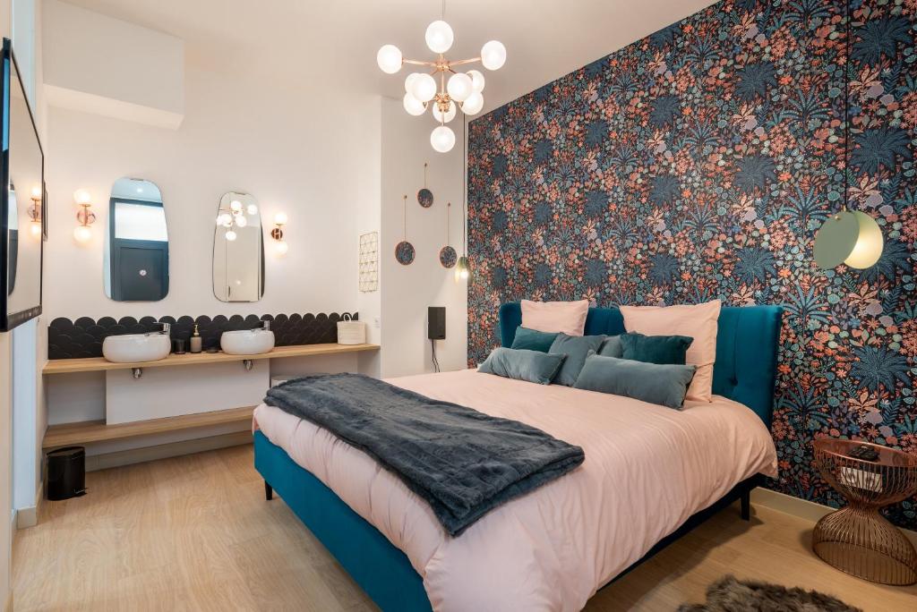 里昂Le Cocon Hygge & SPA的一间卧室配有蓝色的床和花卉装饰墙