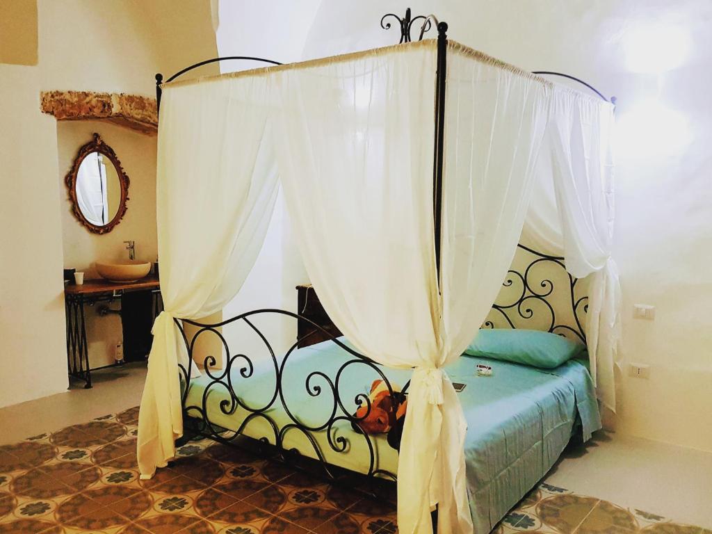马蒂诺La casa dei Bombi Nettare (casa da 2)的卧室配有带白色窗帘的天蓬床