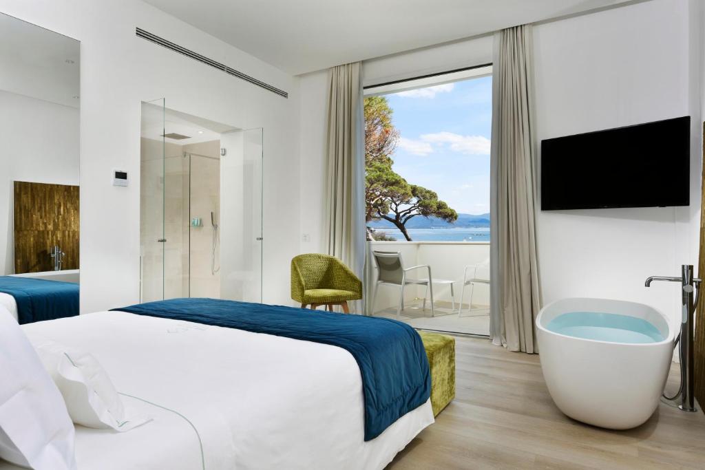 福洛尼卡The Sense Experience Resort的酒店客房设有一张大床和一个浴缸。