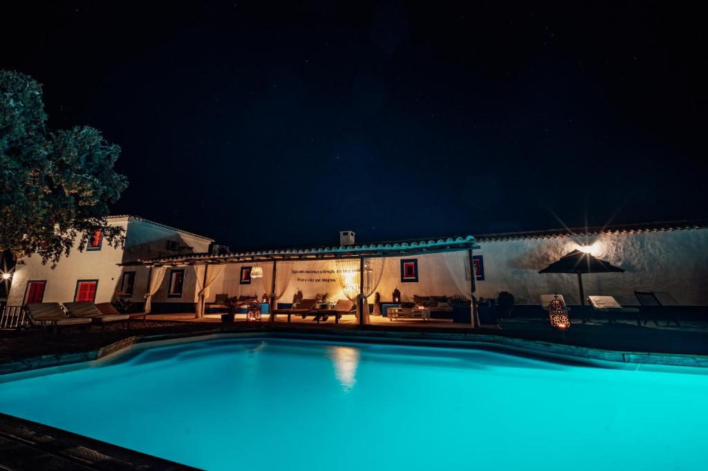 Curvatos蒙吉奥斯乡间别墅温泉酒店的夜间在房子前面的游泳池