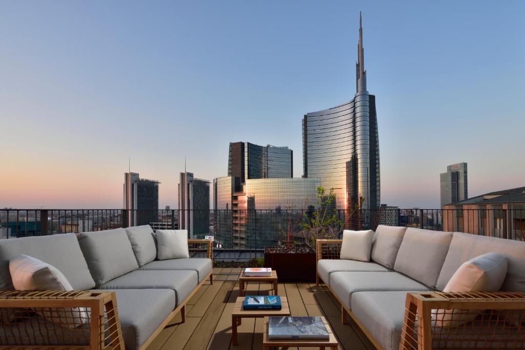 米兰Milano Verticale | UNA Esperienze的带沙发的屋顶露台,享有城市美景