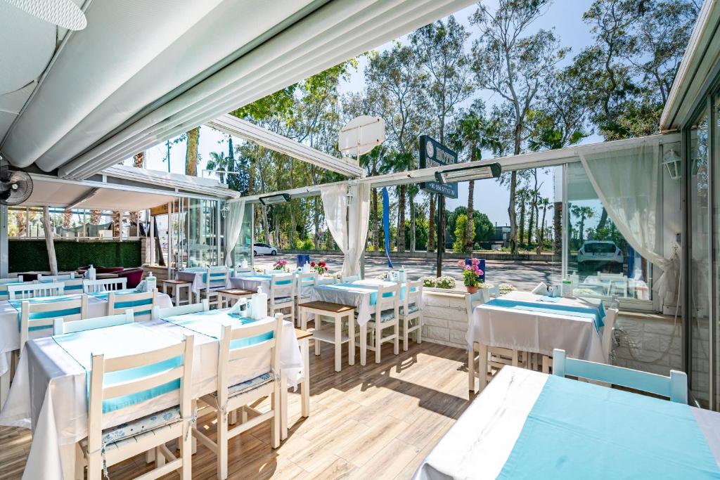 安塔利亚Sare Beach Hotel的一间设有蓝色和白色桌椅的餐厅