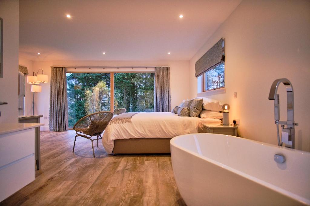 Benderloch阿尔多纳酒店的一间卧室配有一张床和一个浴缸。