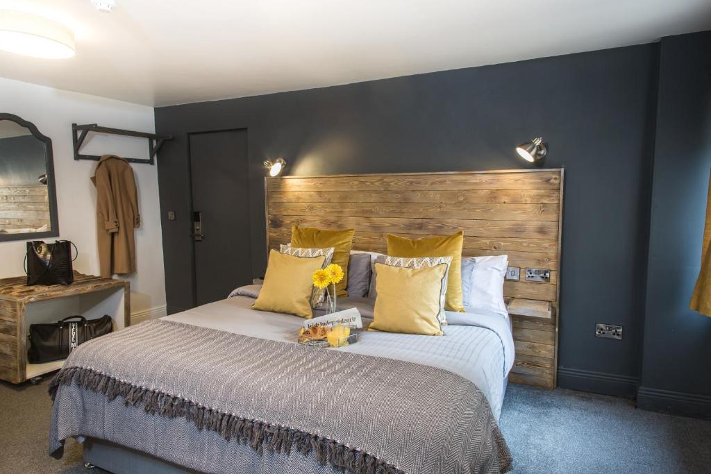 都柏林都柏林蒂珀雷豪斯酒店的一间卧室配有一张大床和木制床头板