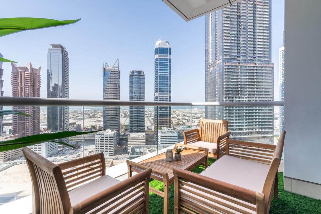 迪拜Business Bay Apt with Rooftop Pool, Fast WiFi, and near Burj Khalifa的阳台配有2把椅子和桌子