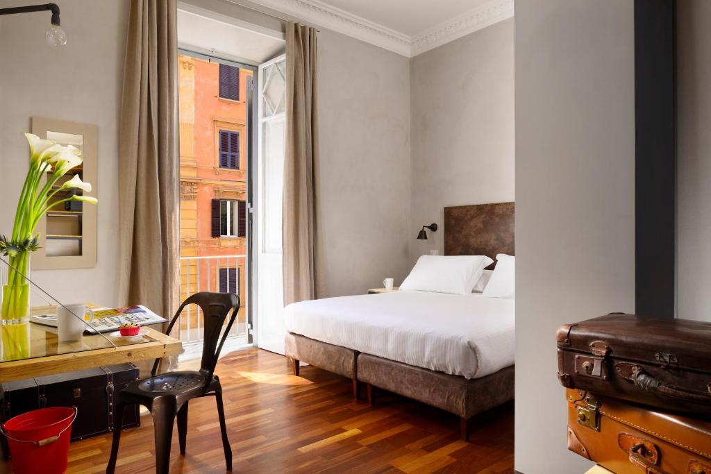 罗马圣彼得精品客房旅馆的一间卧室配有一张床、一张书桌和一个窗户。