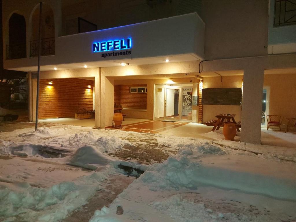 奥瑞斯蒂亚斯Nefeli Apartments Ορεστιάδα的前面的地面上积雪的建筑