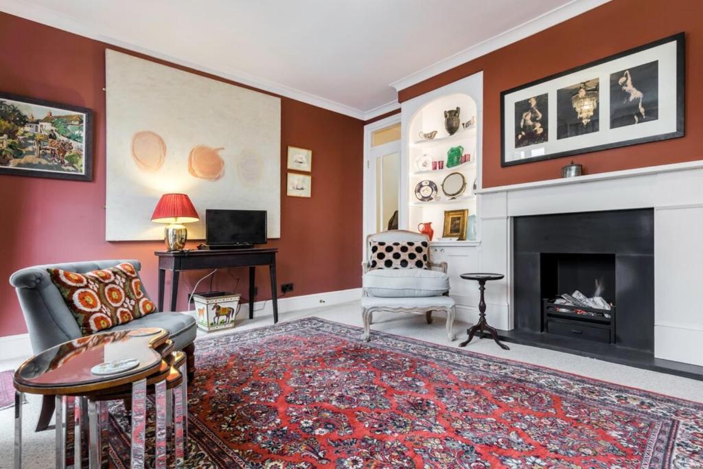 伦敦3 bedroom Apartment on Portobello Road in Notting Hill的客厅设有红色的墙壁和壁炉