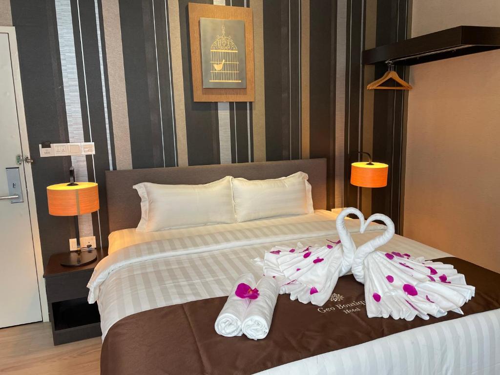 史里肯邦安Geo Boutique Hotel - Seri Kembangan的酒店客房,配有一张带两双拖鞋的床