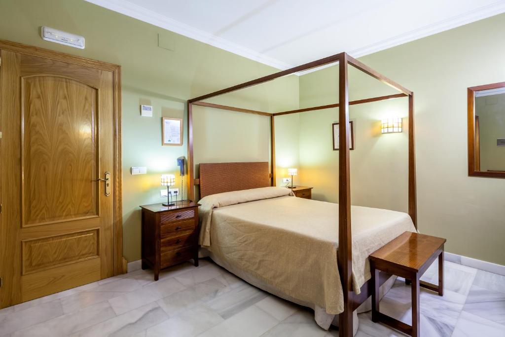 奥苏纳Hotel Las Casas del Duque的一间卧室设有一张天蓬床和木门。