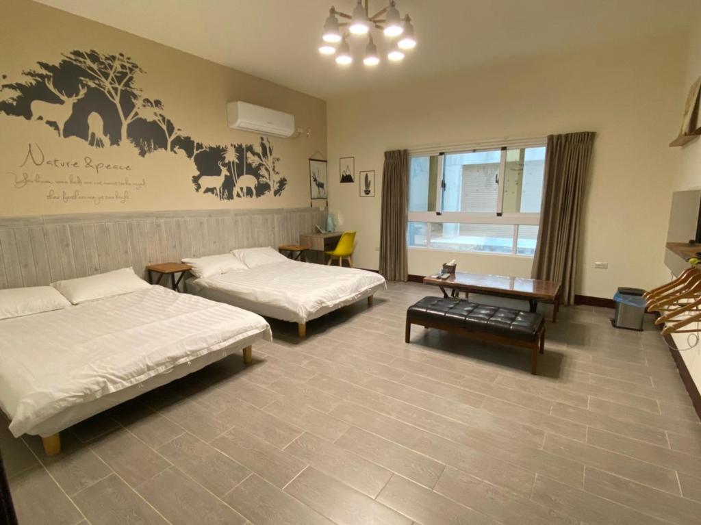 马公澎湖紙飛機民宿Paper Jet B&B的酒店客房设有两张床和一张桌子。