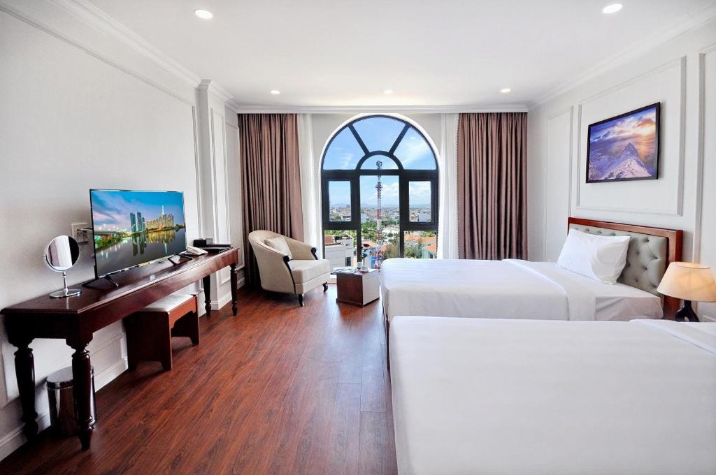 绥和市Sunflower Hotel Phú Yên的酒店客房配有两张床和一张书桌
