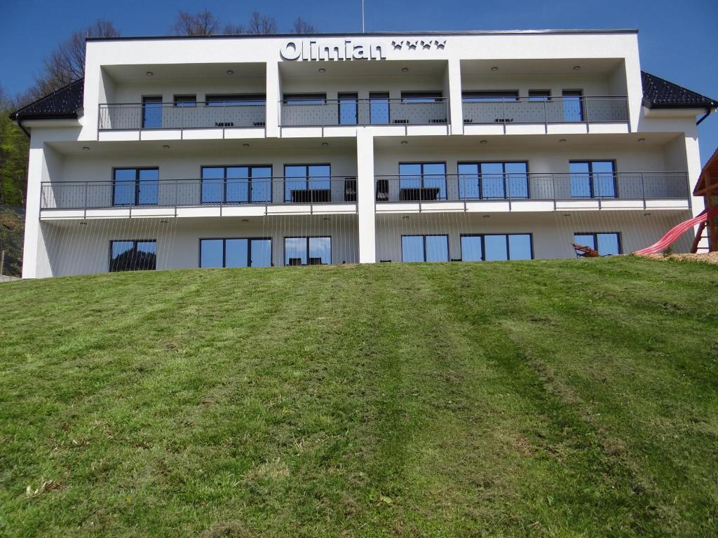博德森特克Relax Center Olimian的一座位于山顶的绿色田野上的建筑