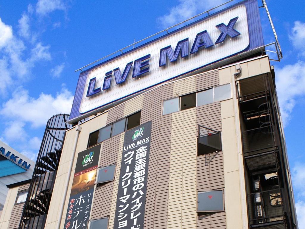 大阪HOTEL LiVEMAX BUDGET Shinosaka的一座大建筑,上面有标志