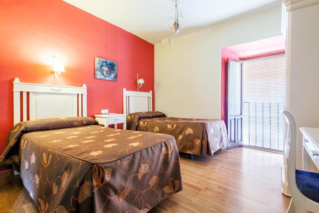 奥苏纳萨尔瓦多布兰科卡瓦略旅舍的一间设有两张床和红色墙壁的客房