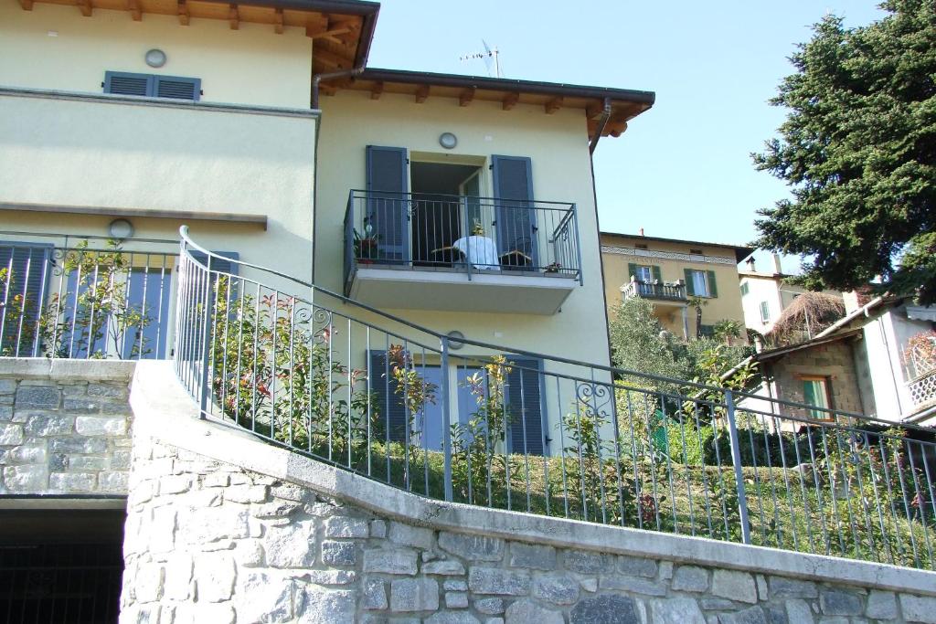 贝拉吉奥Casavalery Appartamento monolocale con vista lago的带阳台的建筑,有男人坐在窗户上