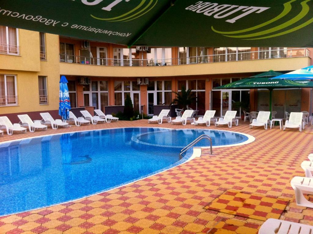阳光海滩Beatris Family Hotel的游泳池,带椅子和遮阳伞