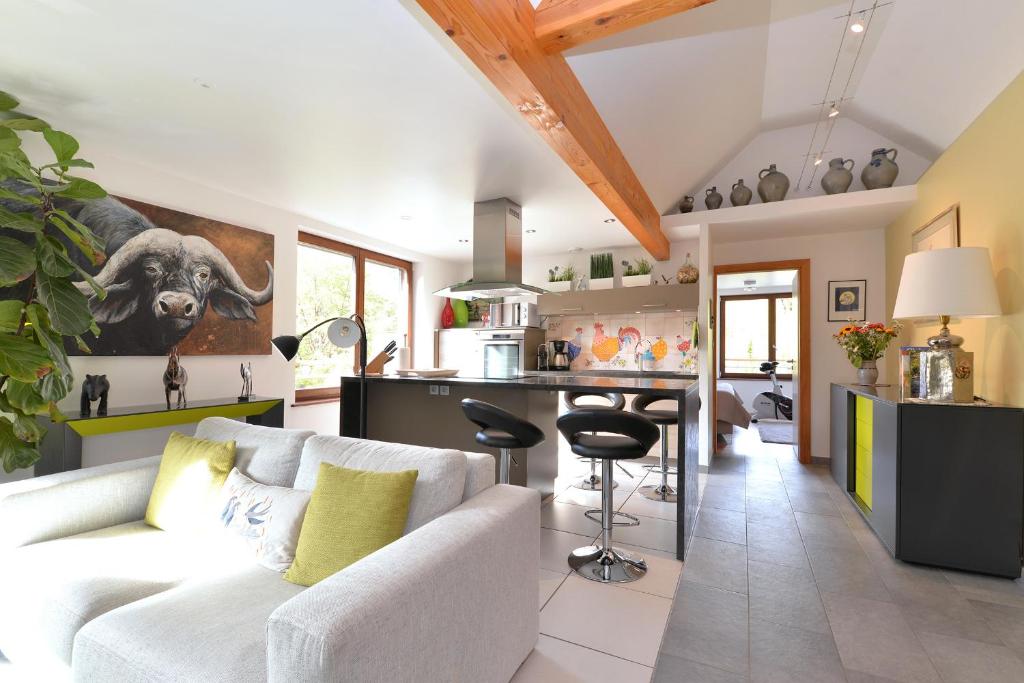 凯泽贝尔Gîte les oiseaux的一间带白色沙发的客厅和一间厨房