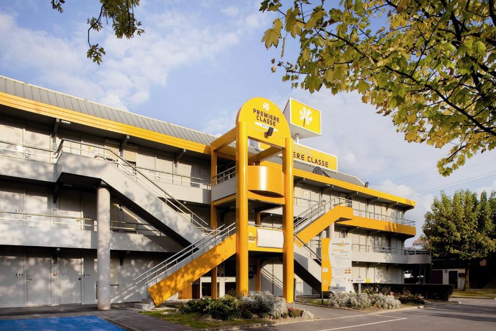 圣洛朗-德米尔东里昂机场圣艾修伯里普瑞米尔经典酒店的前面有黄色标志的建筑