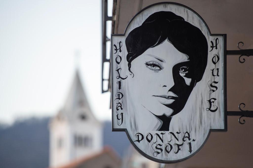 阿杰罗拉Donna Sofi Holiday House的建筑物旁边一个女人的标志