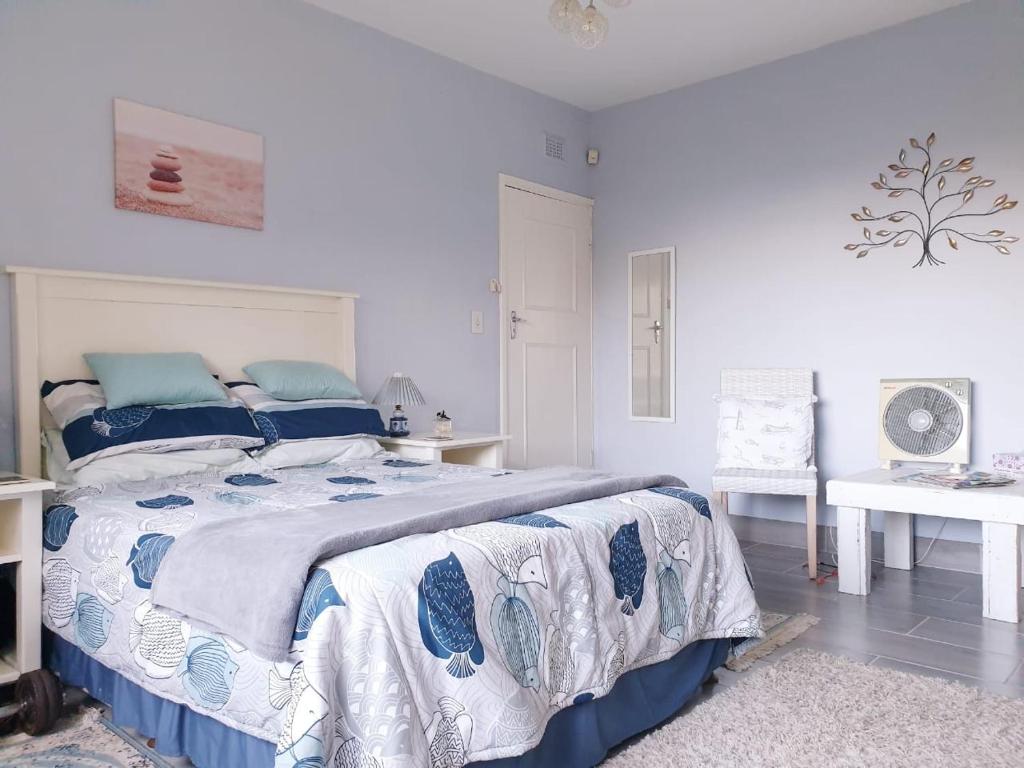 绍斯布鲁姆Whalehaven的一间卧室配有蓝色和白色床单