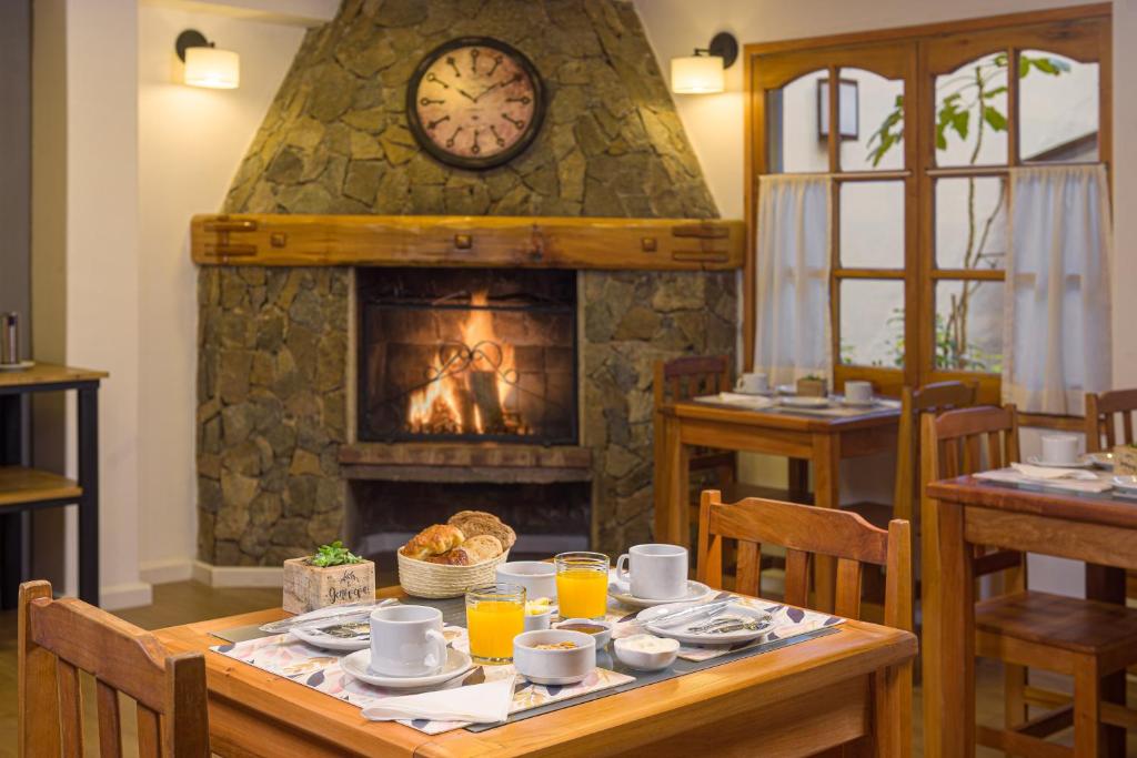 圣马丁德洛斯Hotel Intermonti的一间带壁炉的用餐室,配有一张带食物的桌子