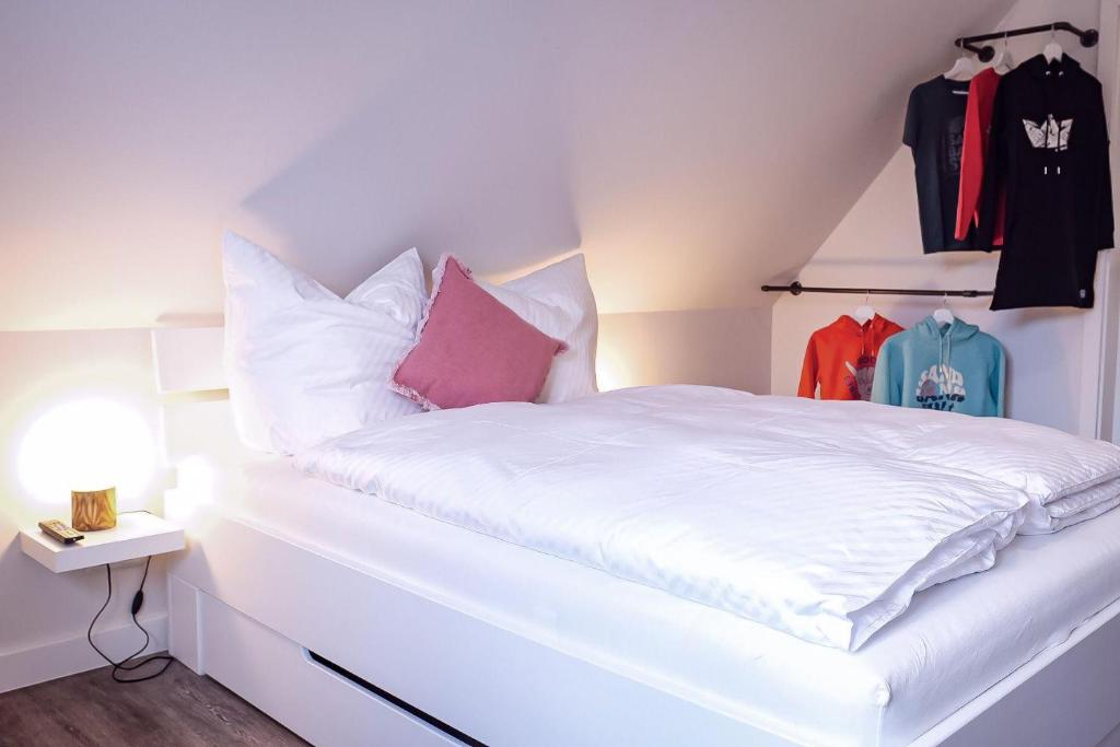 韦斯特兰Flippi-s-Hues-SUeD的一张带白色床单和粉红色枕头的床