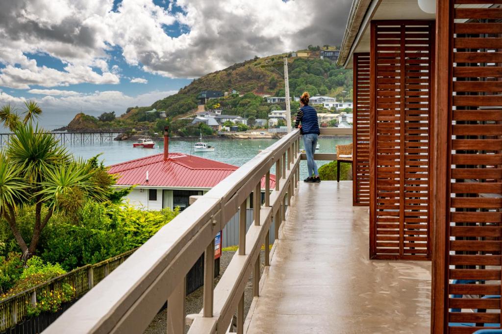 莫拉基Moeraki Beach Motels的站在一个眺望着水面的阳台上的人