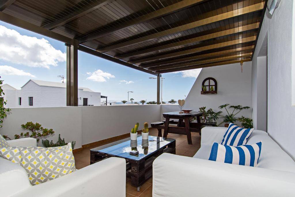 宏达海滩Apartment Fragata的阳台配有白色家具和玻璃桌