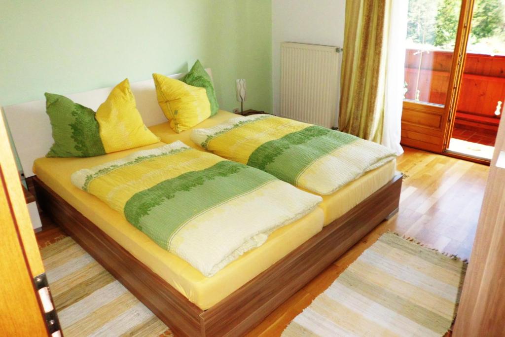 法克湖斯赫利特威瑟公寓的一张带黄色和绿色枕头的床