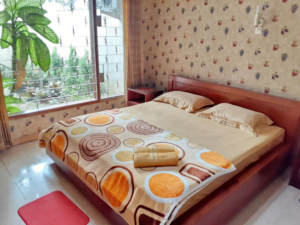 茂物GIO Guesthouse Bogor的卧室内的一张床铺,设有大窗户