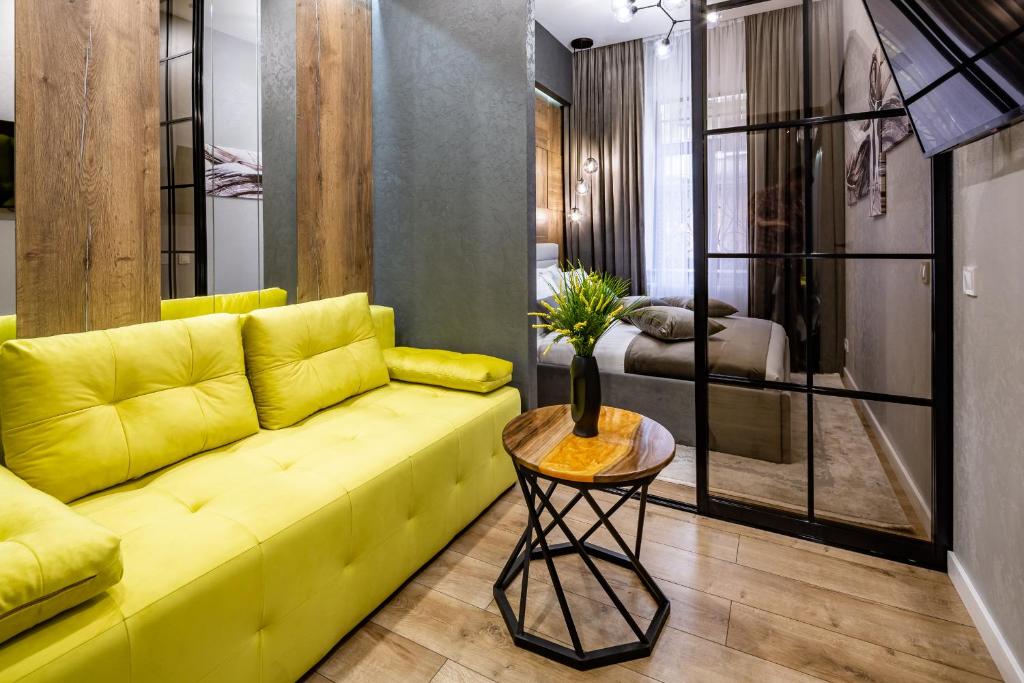 利沃夫Alfa Apartments Kulisha 12的客厅配有黄色的沙发和桌子