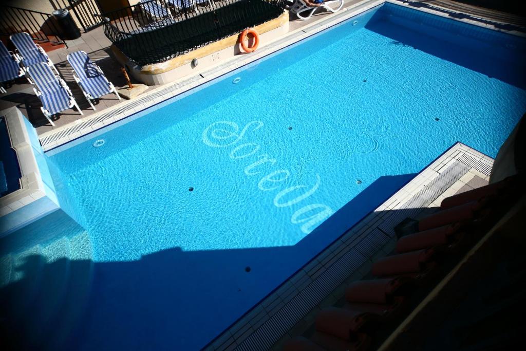 圣保罗湾城索雷达酒店的一个蓝色的游泳池,上面写着游泳池