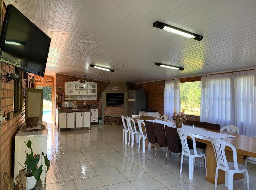 IbicaréSítio com Piscina e Vista a 12km de Treze Tílias的厨房以及带桌椅的用餐室。