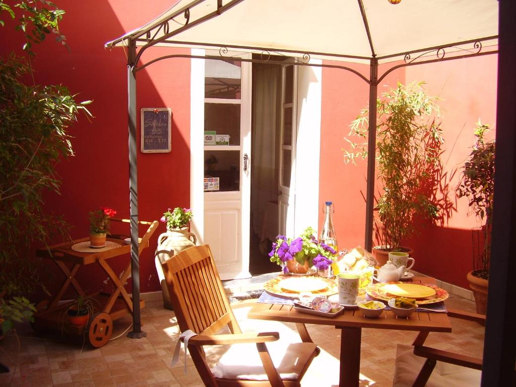 特乌拉达萨托比住宿加早餐旅馆的一个带桌子和遮阳伞的庭院