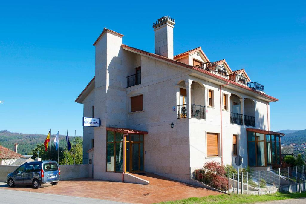 蒙达里斯VILLA ANDURIÑA, casa con piscina cubierta的前面有停车位的建筑