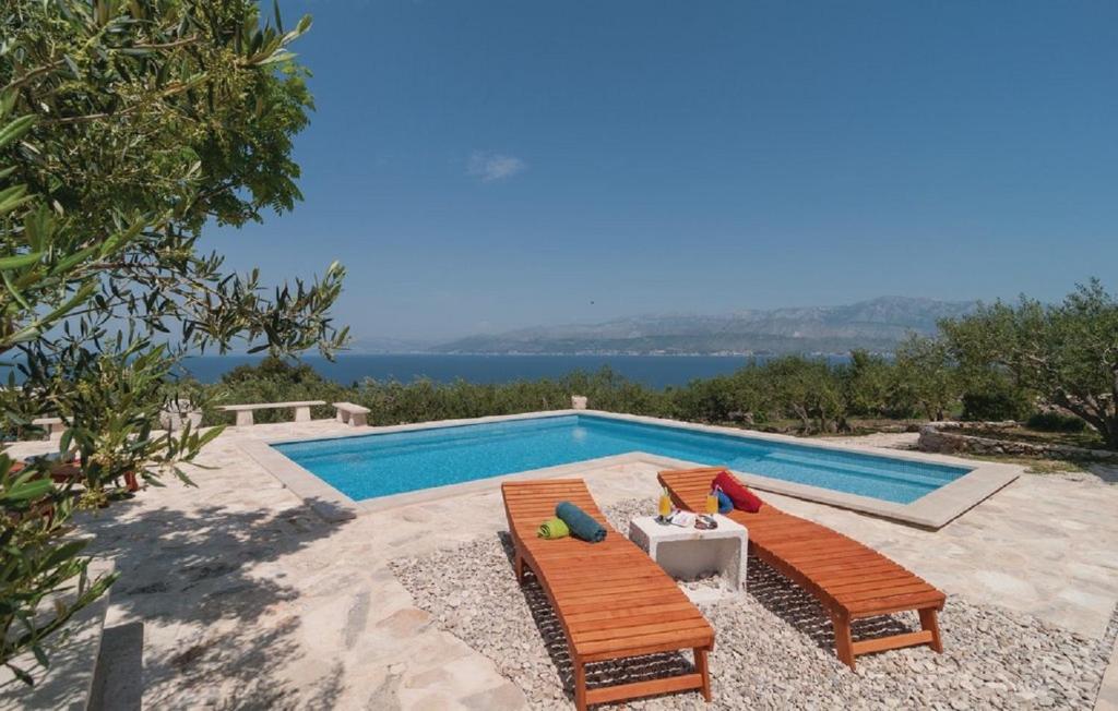 波斯蒂拉Holiday home Glavica的一个带两把椅子和一张桌子的游泳池以及一个游泳池
