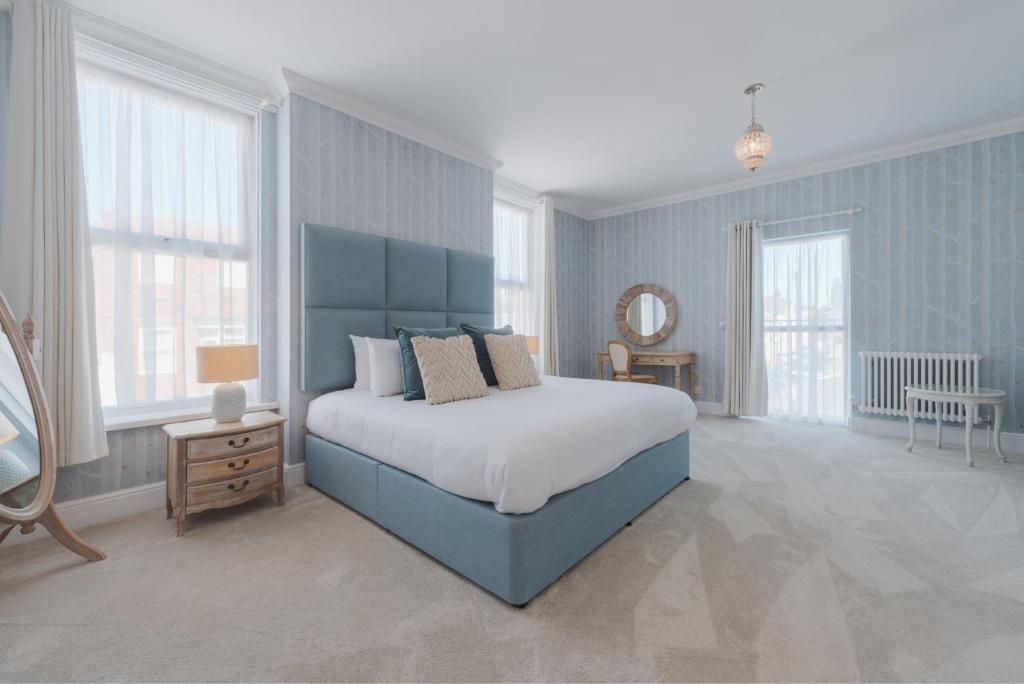 朴次茅斯萨默塞特豪斯精品餐厅酒店的一间蓝色卧室,配有一张床和镜子