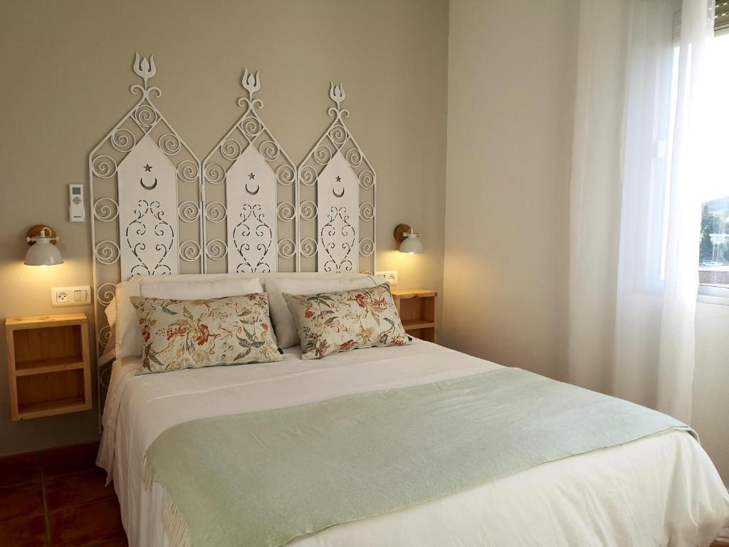 瓜迪亚纳河畔桑卢卡尔洛斯毛利诺斯酒店的一间卧室配有一张大床和大床头板
