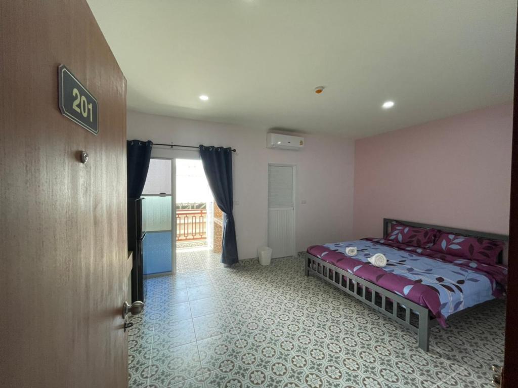 Ban Muang Maiบ้านบัว เมืองใหม่ Baanbua Muangmai的卧室位于客房的角落,配有一张床