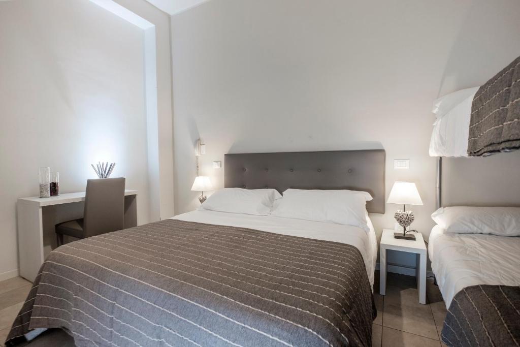 里米尼HOTEL CONDOR的酒店客房设有一张大床和一张书桌。