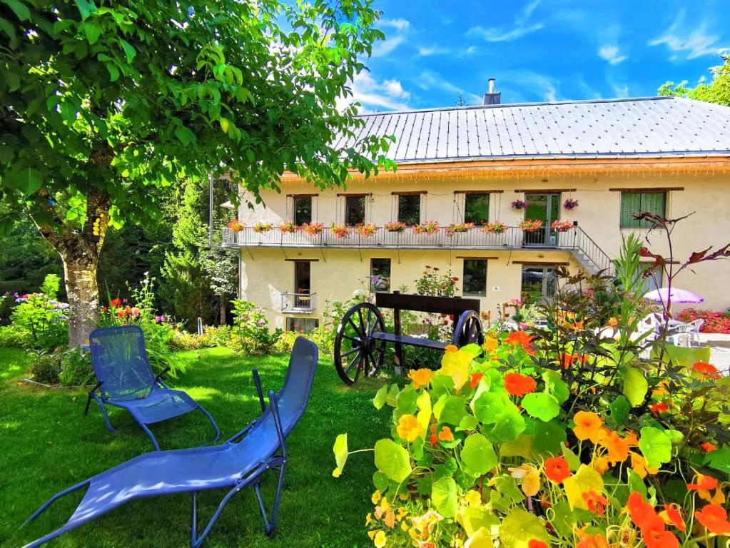 萨莱切Le Moulin des Olirics的两把蓝色椅子放在房子的院子