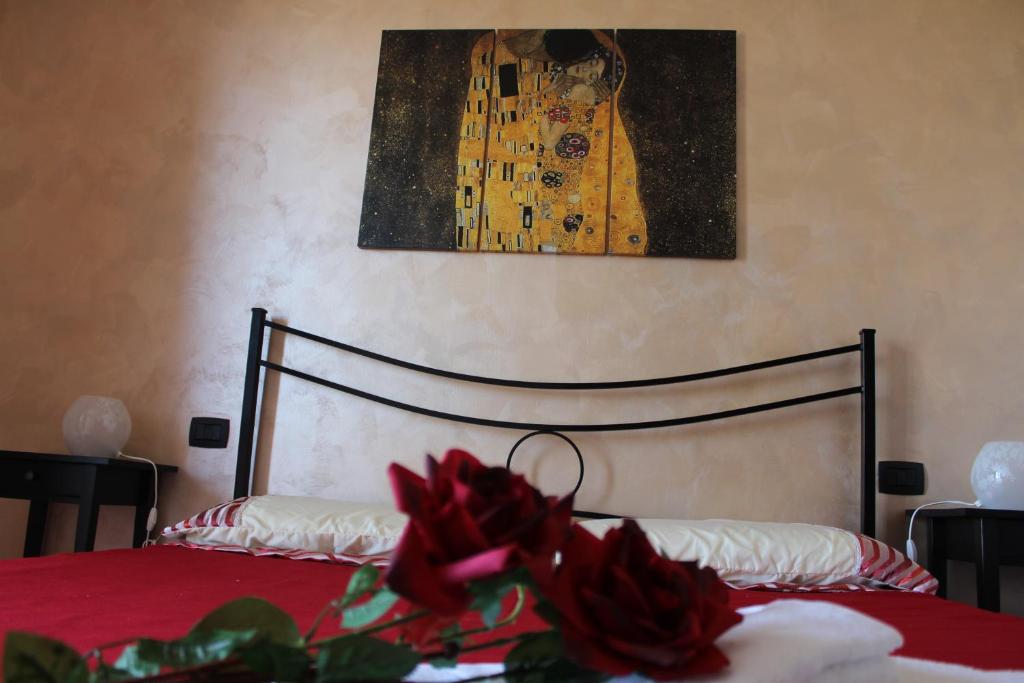 泰尔莫利B&B Colle Sul Mare的一间卧室配有一张带红色床单和绘画的床。